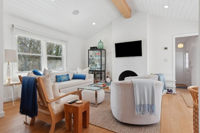 living area with light wood-style floors, recessed lighting, a fireplace, and lofted ceiling with beams