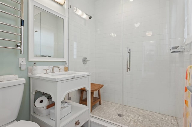 bathroom with a stall shower, vanity, and toilet