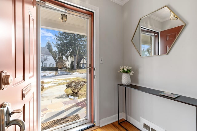 entrance foyer featuring ornamental molding, light wood-style flooring, a wealth of natural light, and baseboards