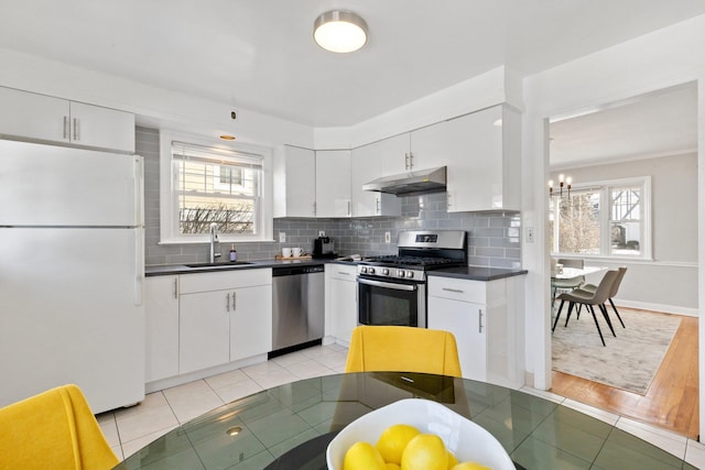 kitchen featuring white cabinets, under cabinet range hood, and stainless steel appliances