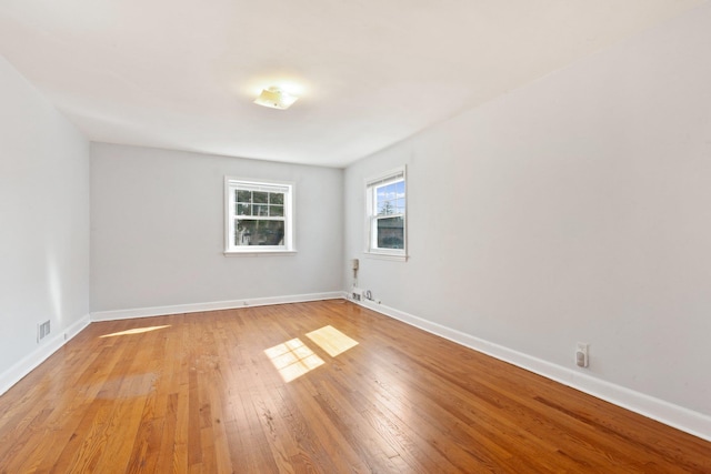 unfurnished room with baseboards, visible vents, and light wood finished floors