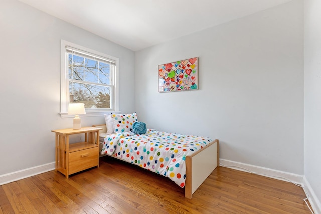 bedroom with baseboards and wood finished floors