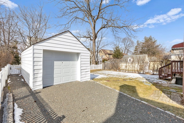 detached garage featuring aphalt driveway and fence