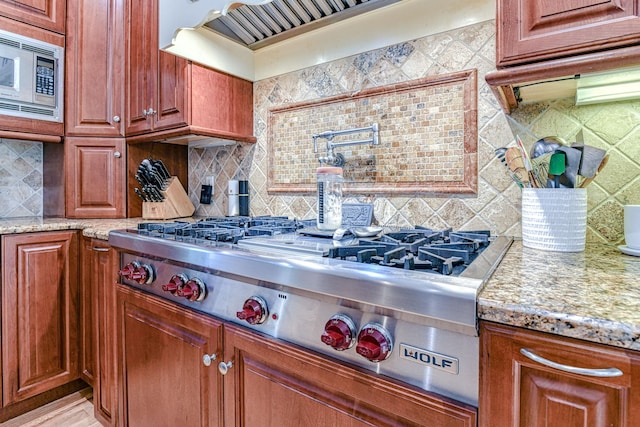 34 Clark Ln, Harriman, NY 10926 - kitchen with appliances with stainless steel finishes, backsplash, premium range hood, light stone countertops, and brown cabinetry