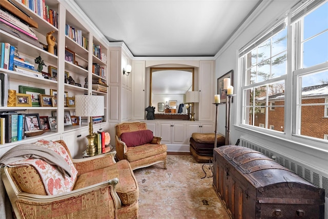 sitting room with crown molding and arched walkways