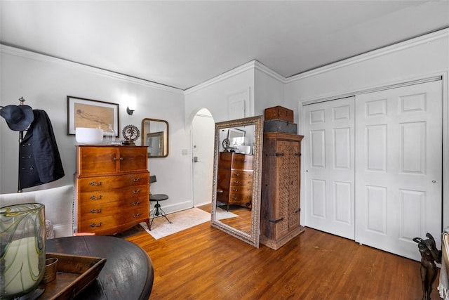 bedroom featuring a closet, hardwood / wood-style flooring, and crown molding