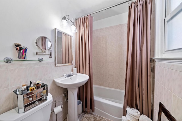 bathroom featuring shower / bath combo, tile walls, and toilet