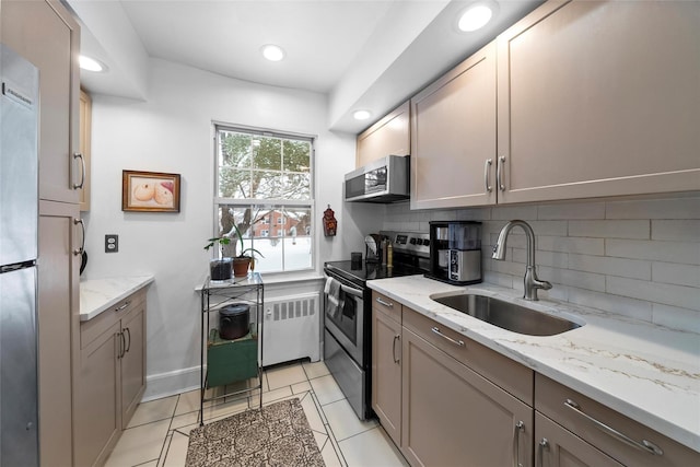 182 Pinewood Rd Unit 26, Hartsdale, NY 10530 - kitchen with radiator, light stone countertops, a sink, stainless steel appliances, and backsplash