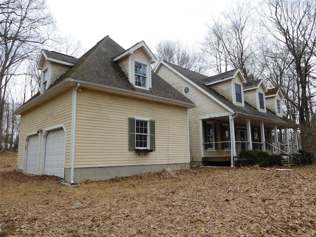 view of property exterior with an attached garage, a sunroom, and roof with shingles