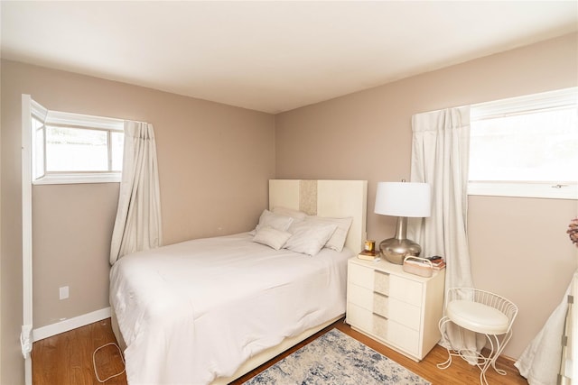 bedroom featuring baseboards and wood finished floors