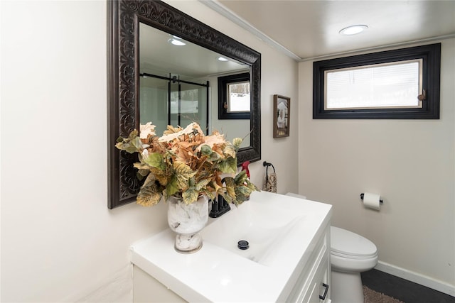 bathroom featuring a stall shower, baseboards, toilet, ornamental molding, and vanity