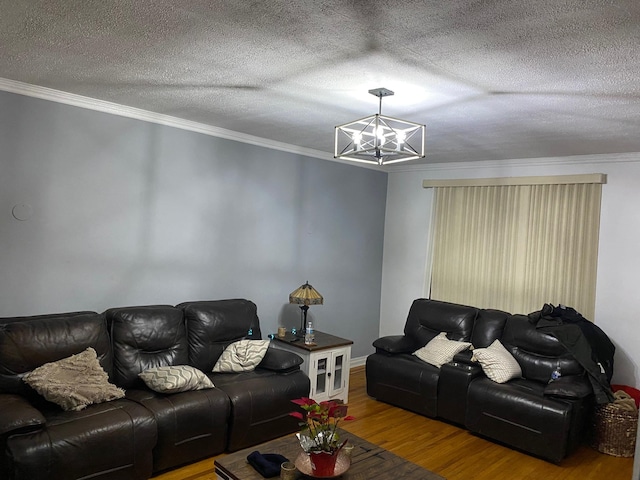 living room with crown molding, wood-type flooring, a chandelier, and a textured ceiling