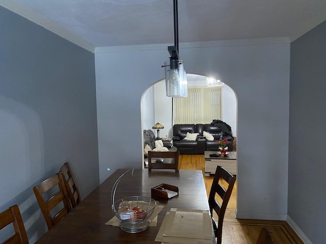 dining space with ornamental molding and hardwood / wood-style floors