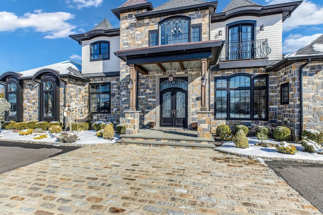 view of front of home with stone siding and french doors