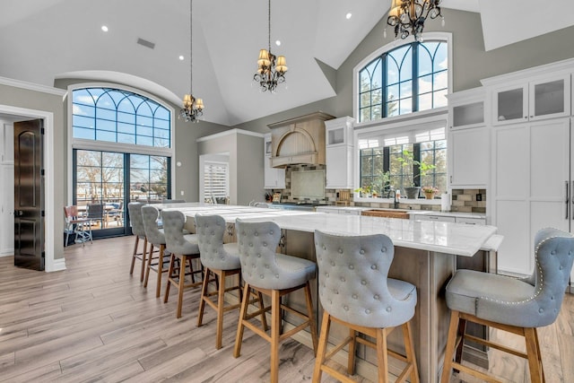 kitchen featuring glass insert cabinets, a kitchen island, and an inviting chandelier