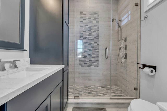 bathroom featuring a stall shower, vanity, and toilet