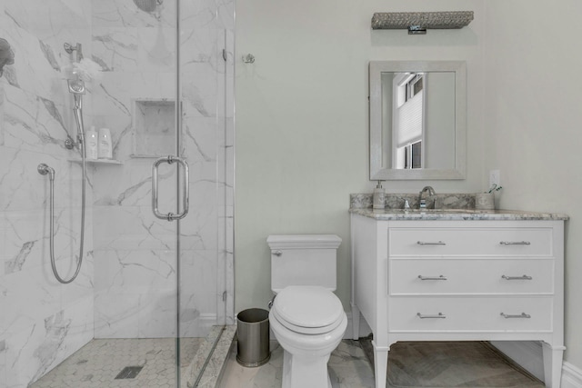 bathroom featuring vanity, a marble finish shower, and toilet