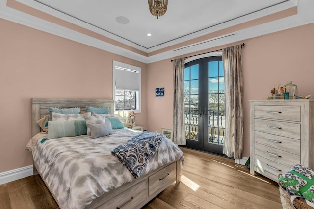 bedroom with access to outside, french doors, a raised ceiling, and crown molding