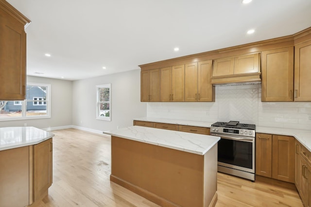 kitchen featuring light wood-style flooring, stainless steel range with gas cooktop, and tasteful backsplash