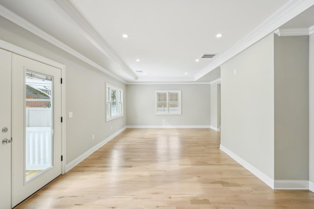 spare room featuring light wood-style flooring, visible vents, and crown molding