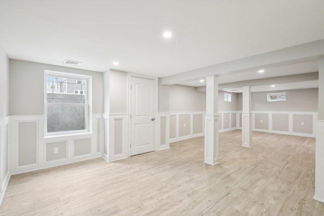 basement featuring light wood-type flooring, visible vents, and recessed lighting