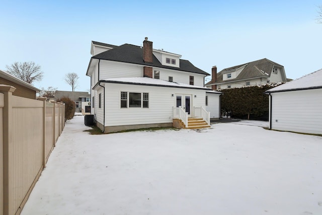 rear view of property featuring central AC unit, a chimney, fence, and french doors