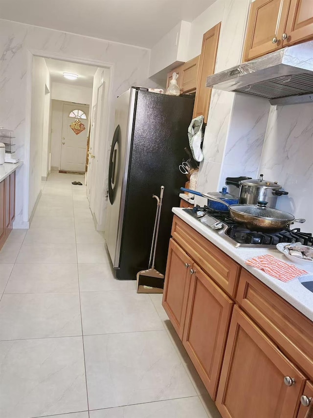 kitchen featuring tasteful backsplash, appliances with stainless steel finishes, and light tile patterned floors