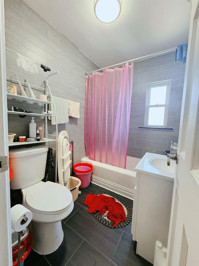 full bathroom with tile walls, shower / bath combination with curtain, vanity, toilet, and tile patterned floors