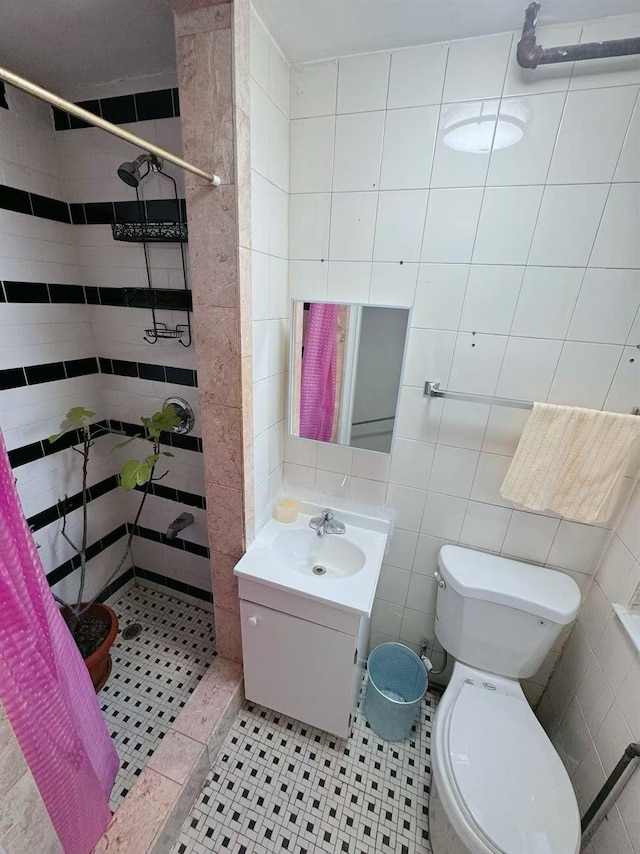 bathroom with tile walls, vanity, and walk in shower