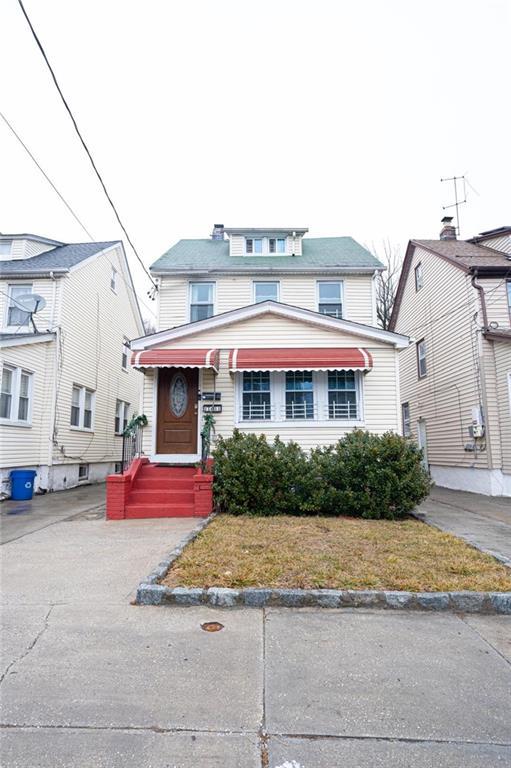 american foursquare style home featuring a front lawn