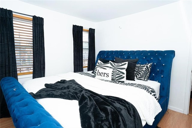 bedroom with baseboards and wood finished floors