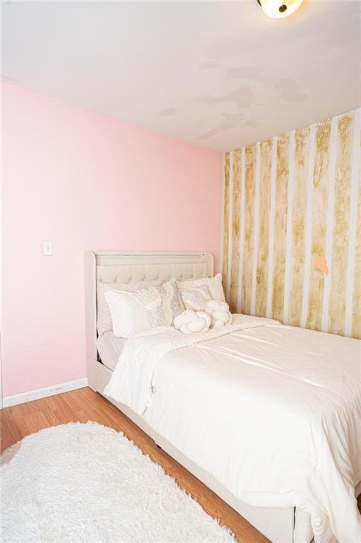 bedroom with baseboards and wood finished floors