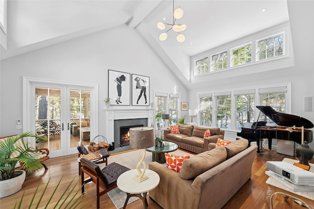 9 Owls Nest Ln, East Hampton, NY 11937 - living area with high vaulted ceiling, french doors, beamed ceiling, a warm lit fireplace, and a chandelier