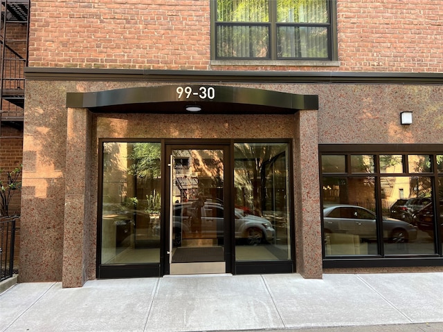 doorway to property featuring brick siding