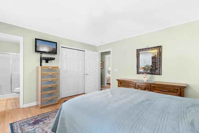 bedroom featuring ensuite bath, a closet, and light wood-type flooring