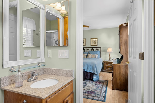 bathroom with vanity, hardwood / wood-style flooring, and a shower with door