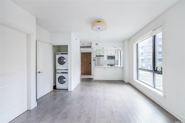 interior space featuring hardwood / wood-style flooring and stacked washing maching and dryer