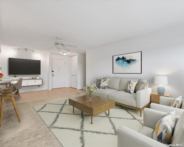 living room featuring wood-type flooring, track lighting, and ceiling fan