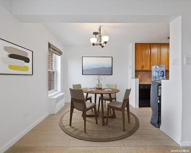 dining room with an inviting chandelier, radiator, and light hardwood / wood-style floors