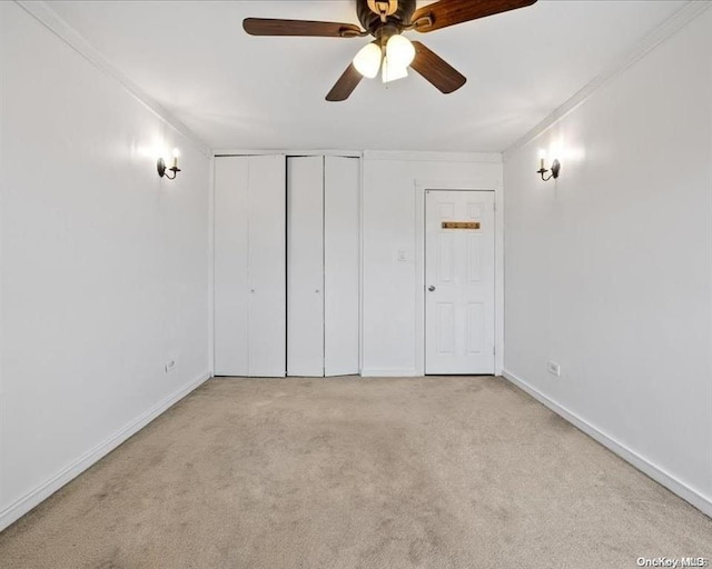 unfurnished bedroom featuring crown molding, light colored carpet, a closet, and ceiling fan