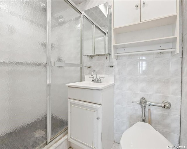 bathroom featuring vanity, toilet, tile walls, and walk in shower