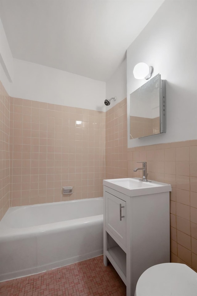 full bathroom with tile patterned floors, toilet, tile walls, vanity, and tiled shower / bath combo