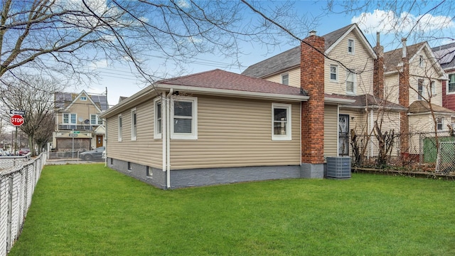 back of property featuring a lawn and central air condition unit