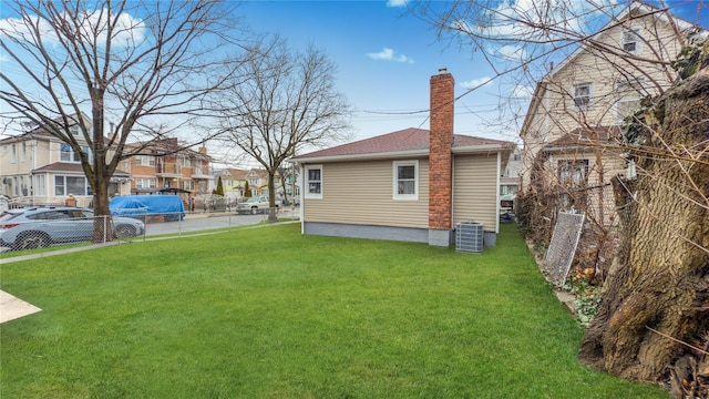 view of side of property with cooling unit and a yard