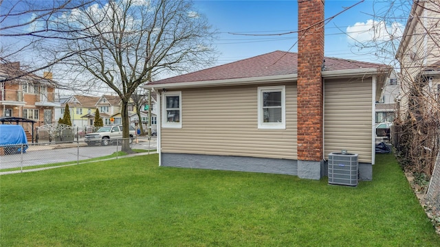 view of home's exterior featuring central AC unit and a yard