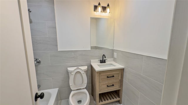 bathroom with vanity, tile walls, and toilet