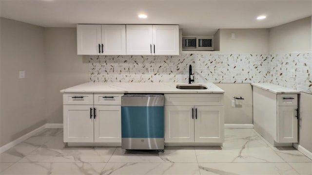 kitchen with white cabinetry, light stone counters, sink, and decorative backsplash