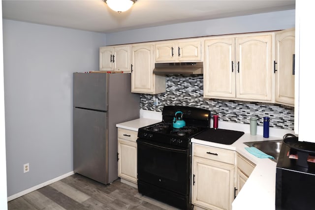 kitchen featuring sink, stainless steel refrigerator, wood-type flooring, gas stove, and decorative backsplash