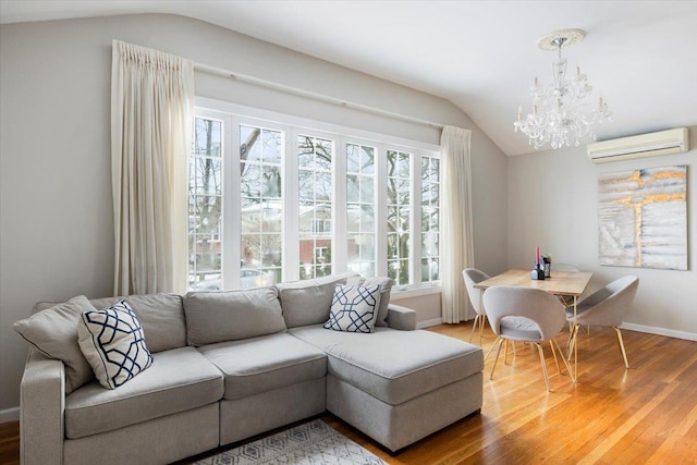 living room with a chandelier, wood-type flooring, a wall mounted AC, and vaulted ceiling