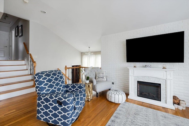 living room featuring hardwood / wood-style floors, vaulted ceiling, and a chandelier